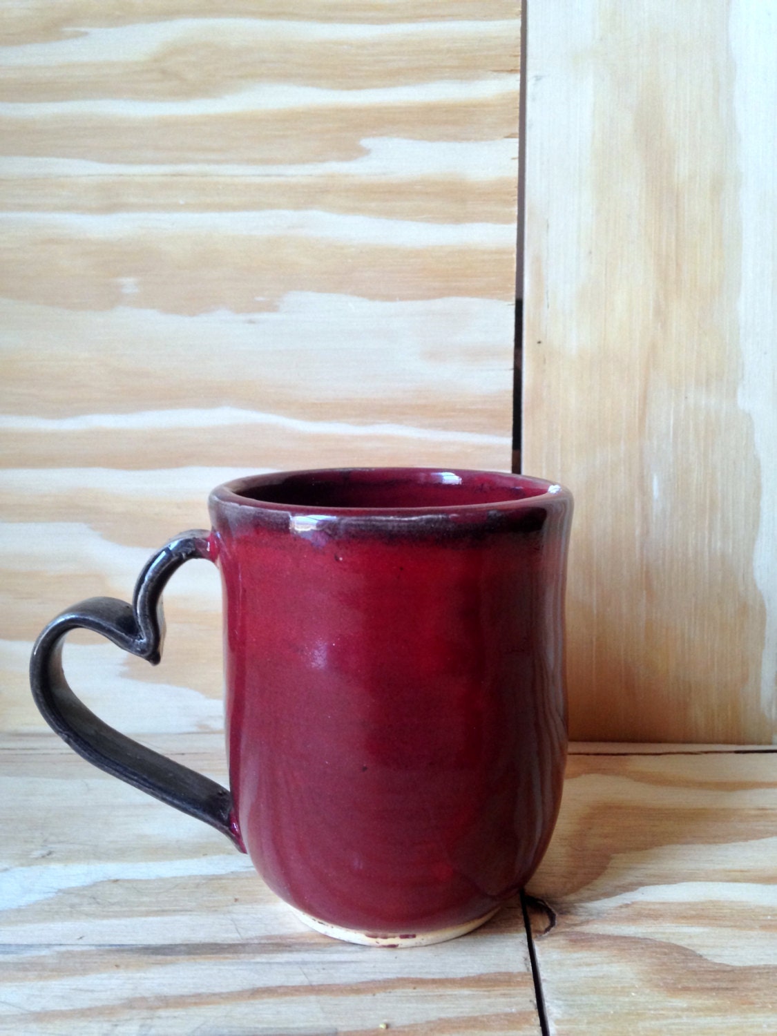 Handmade black and red ceramic coffee mug with heart shaped handle