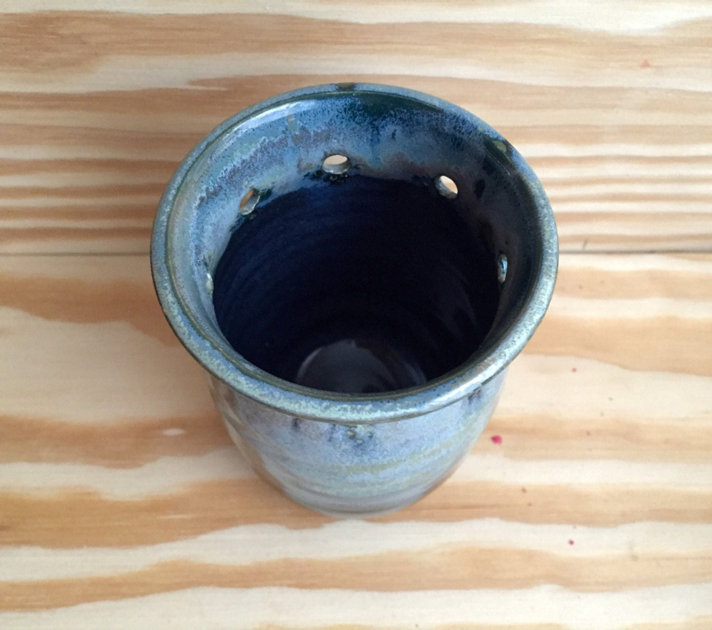 Handmade ceramic bud vase with flower cut out in shades of blue