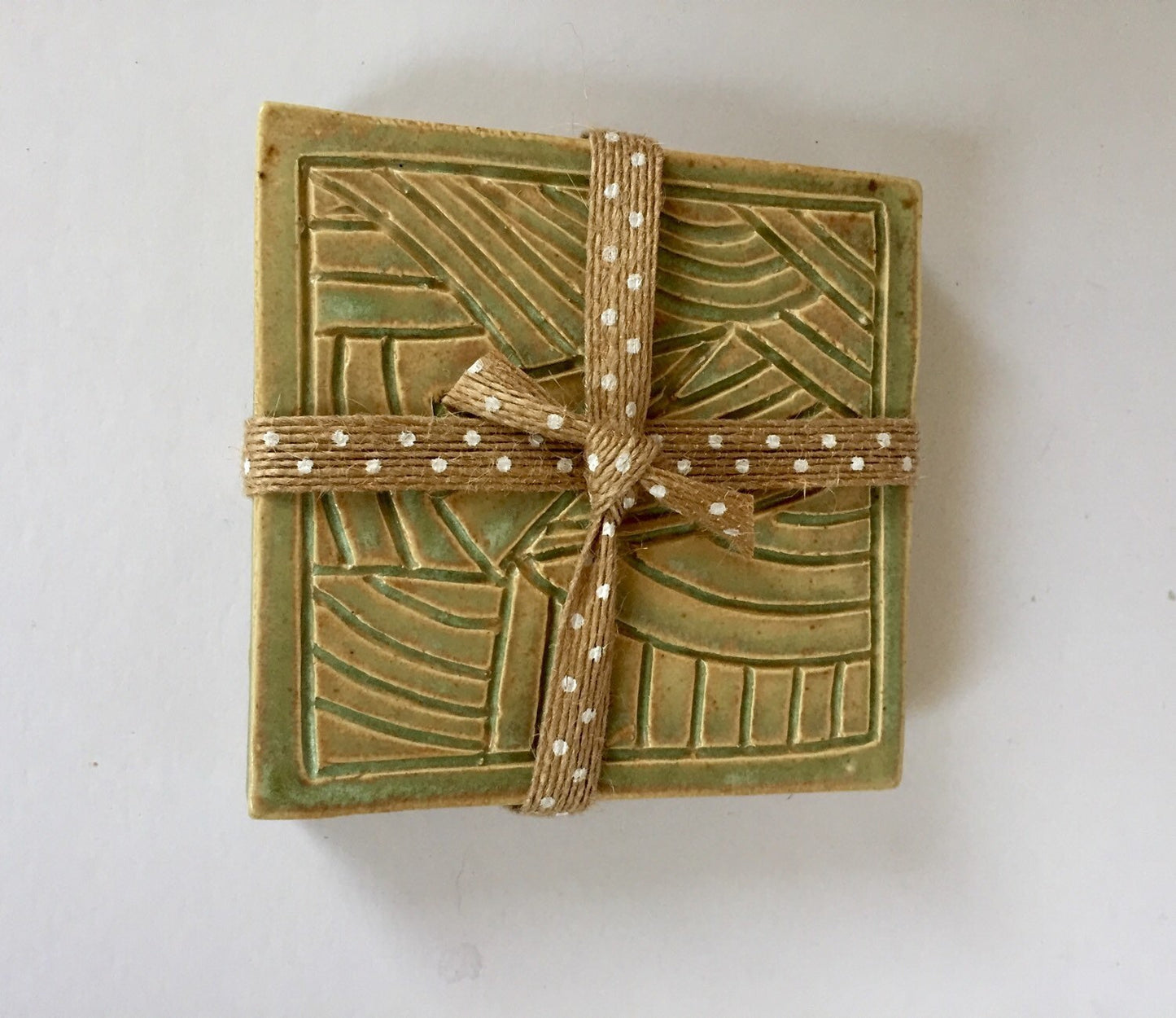 ceramic green coaster set of two with hand carved design