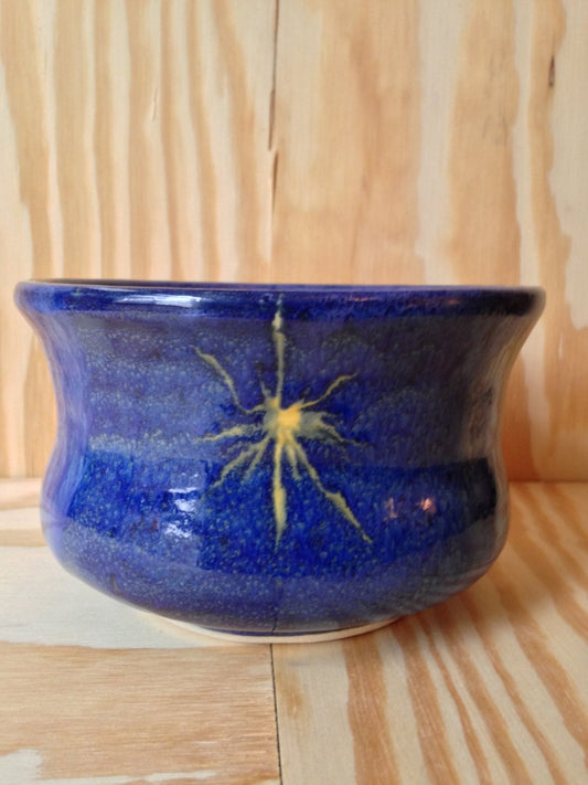 beautiful medium sized bowl in colbalt blue with a waxed in yellow star pattern