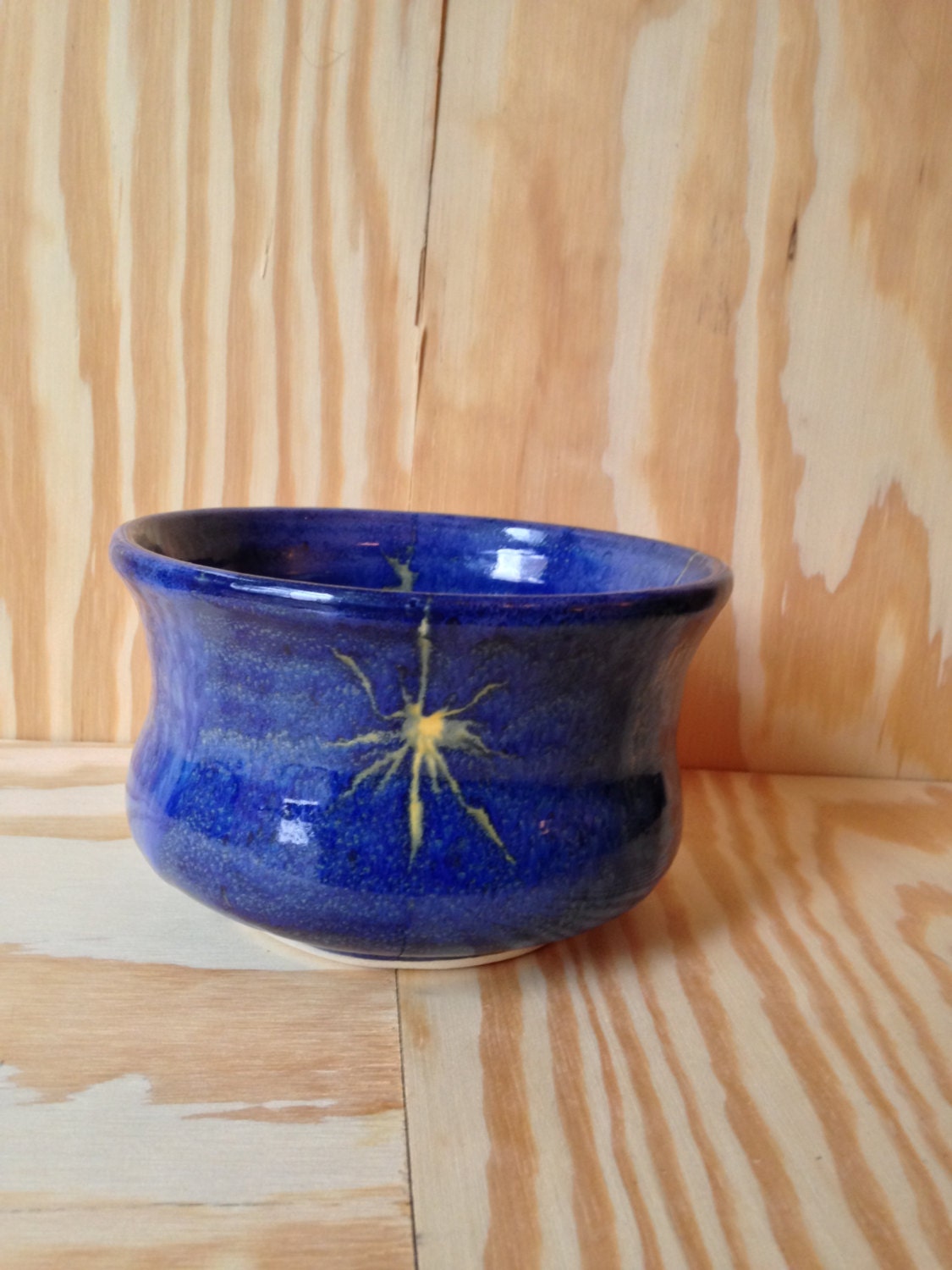 beautiful medium sized bowl in colbalt blue with a waxed in yellow star pattern