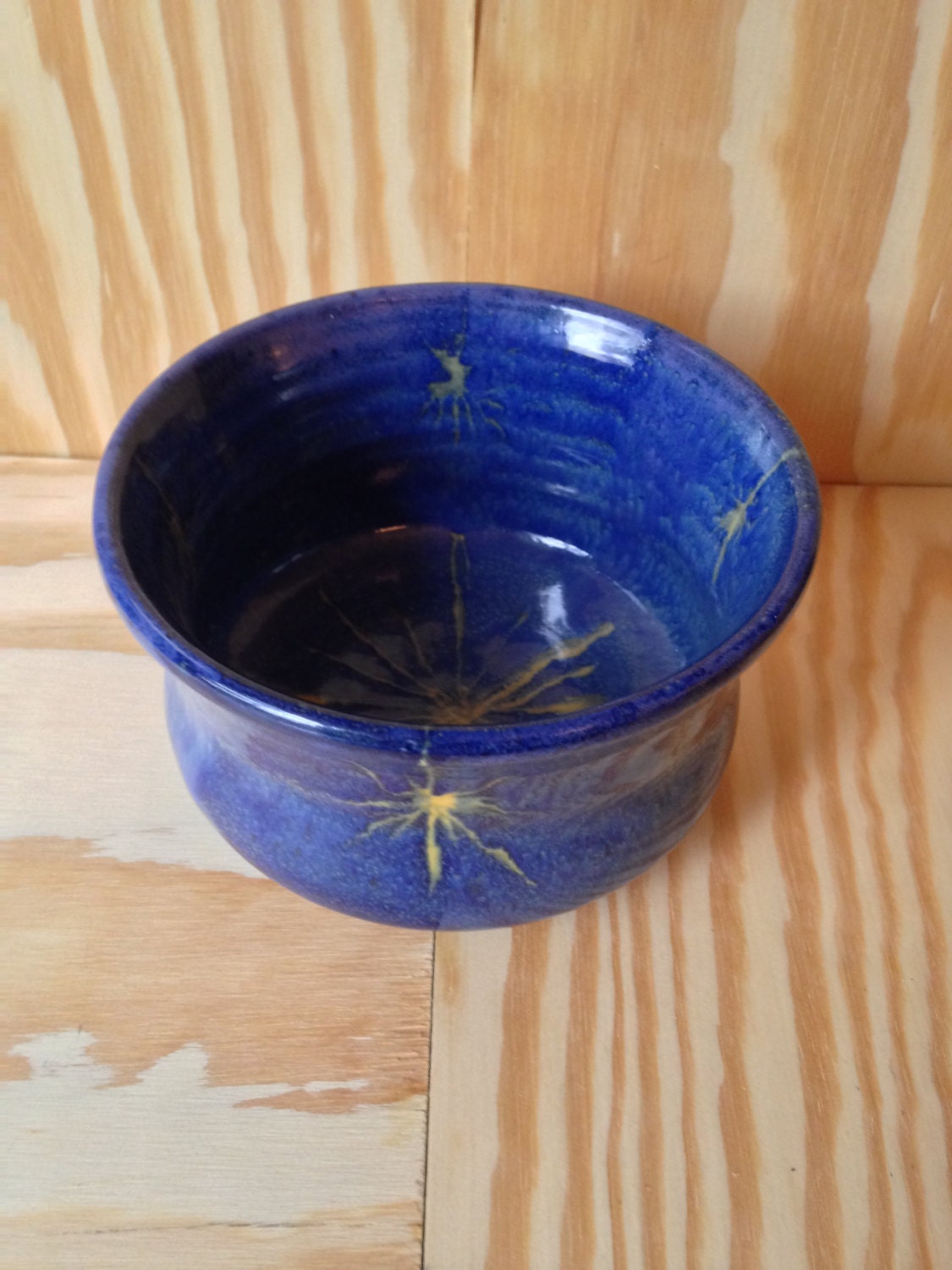 beautiful medium sized bowl in colbalt blue with a waxed in yellow star pattern
