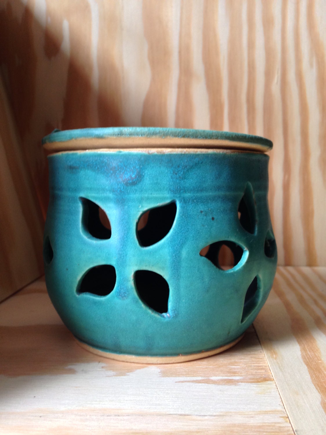 Teal melted wax warmer with hand cut out leaf pattern.