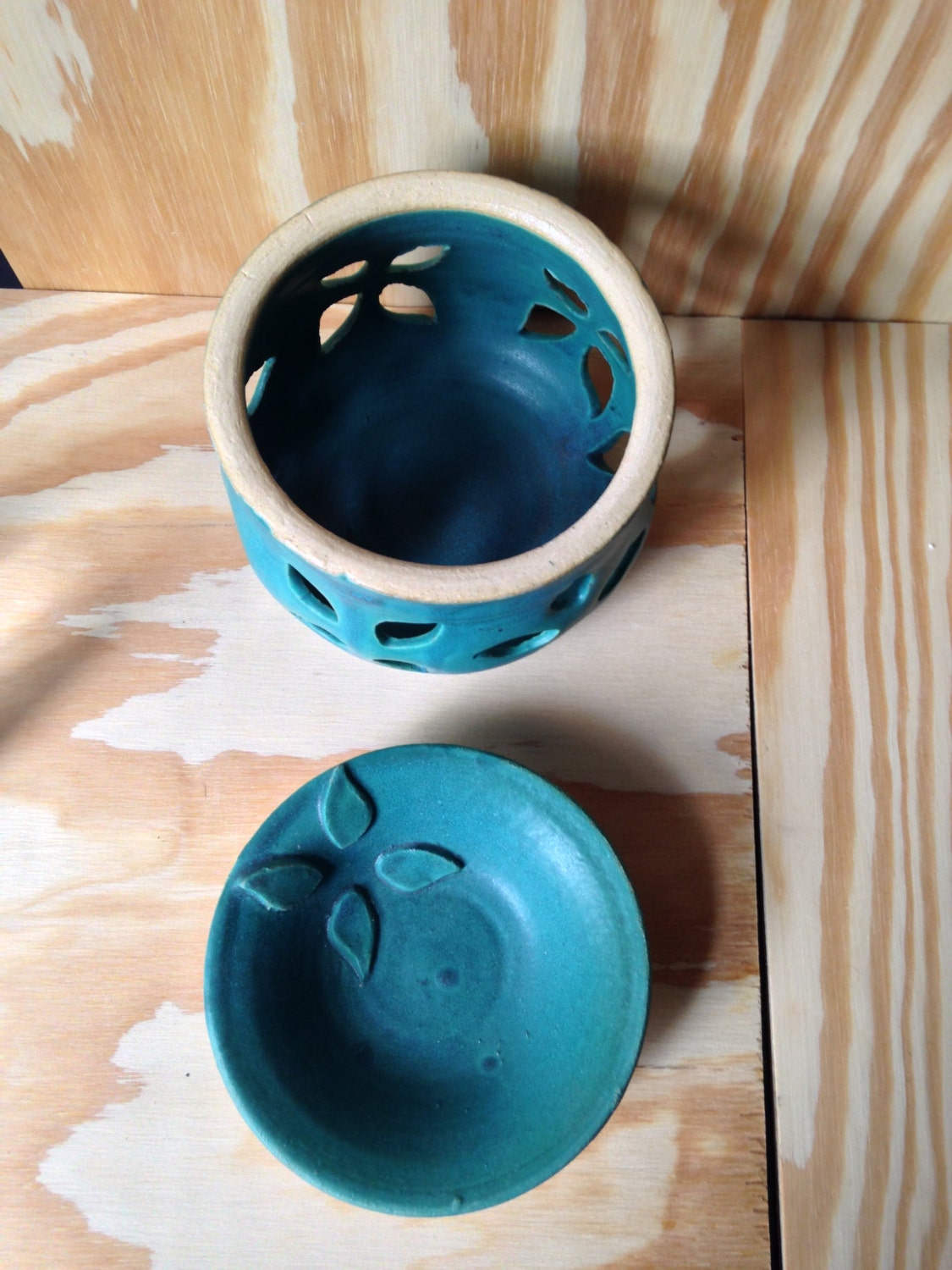 Teal melted wax warmer with hand cut out leaf pattern.