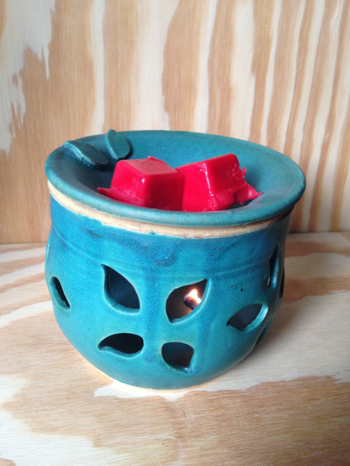 Teal melted wax warmer with hand cut out leaf pattern.