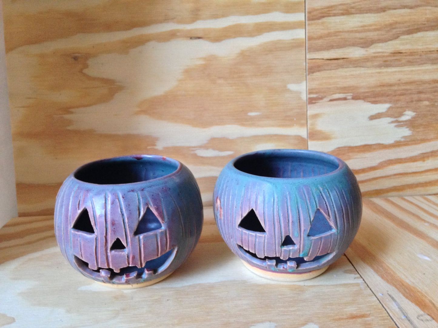 Green and red ceramic candle holder with carved pumpkin design