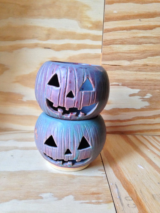 Green and red ceramic candle holder with carved pumpkin design