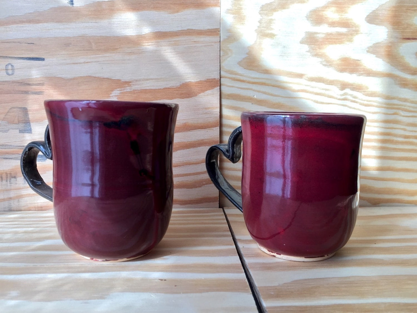 Handmade black and red ceramic coffee mug with heart shaped handle