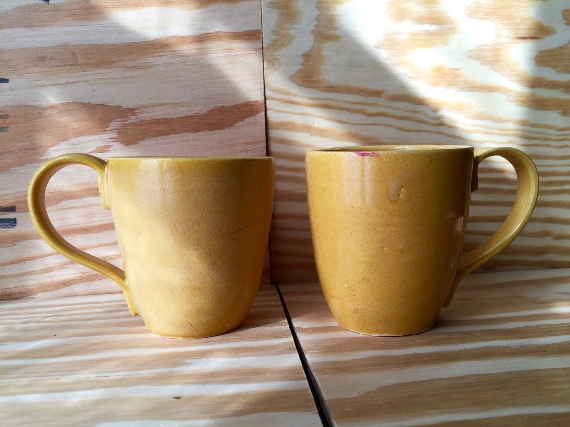Set of two hand made ceramic coffee mugs in warm daffodil yellow