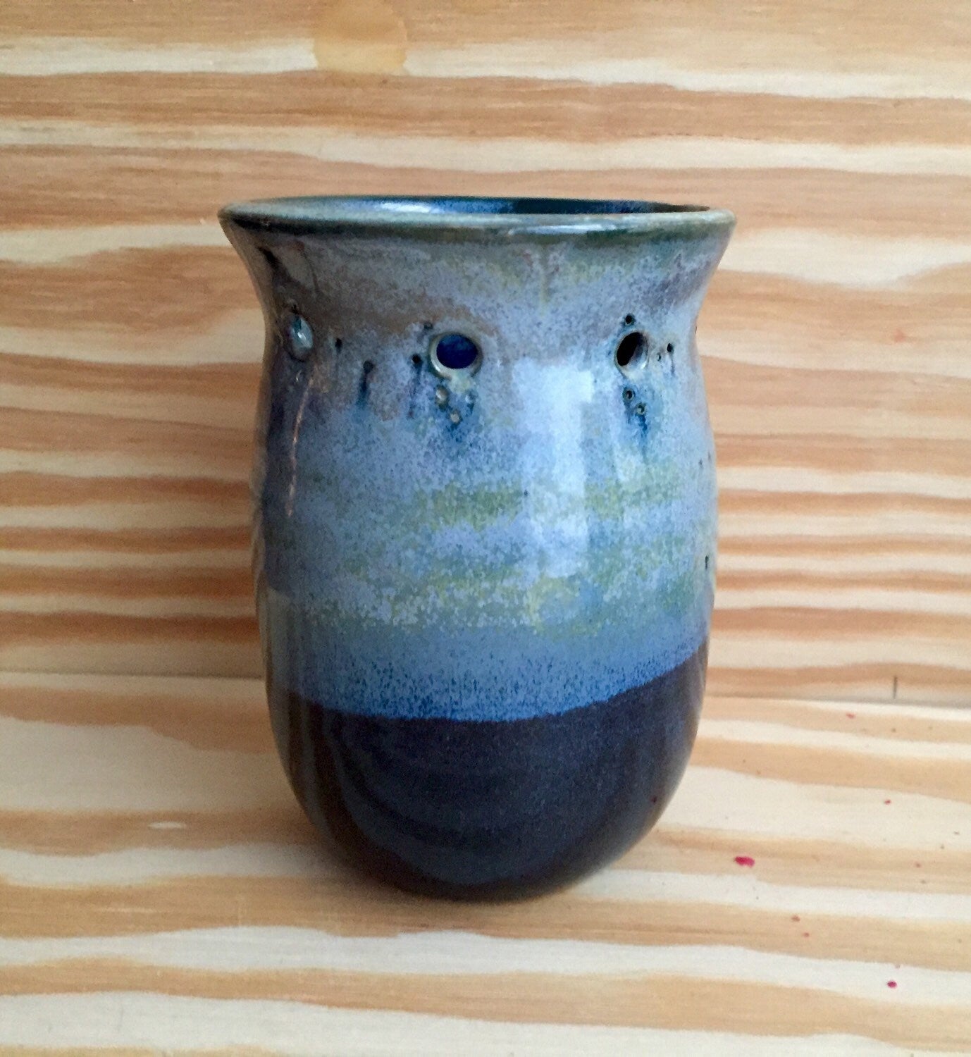 Handmade ceramic bud vase with flower cut out in shades of blue