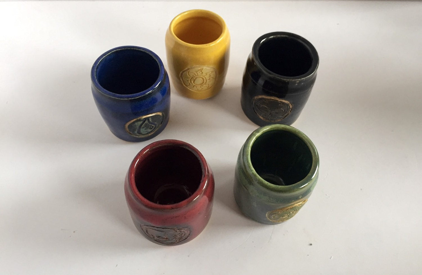 Handmade "magic the gathering" themed ceramic shot glasses with the five basic land