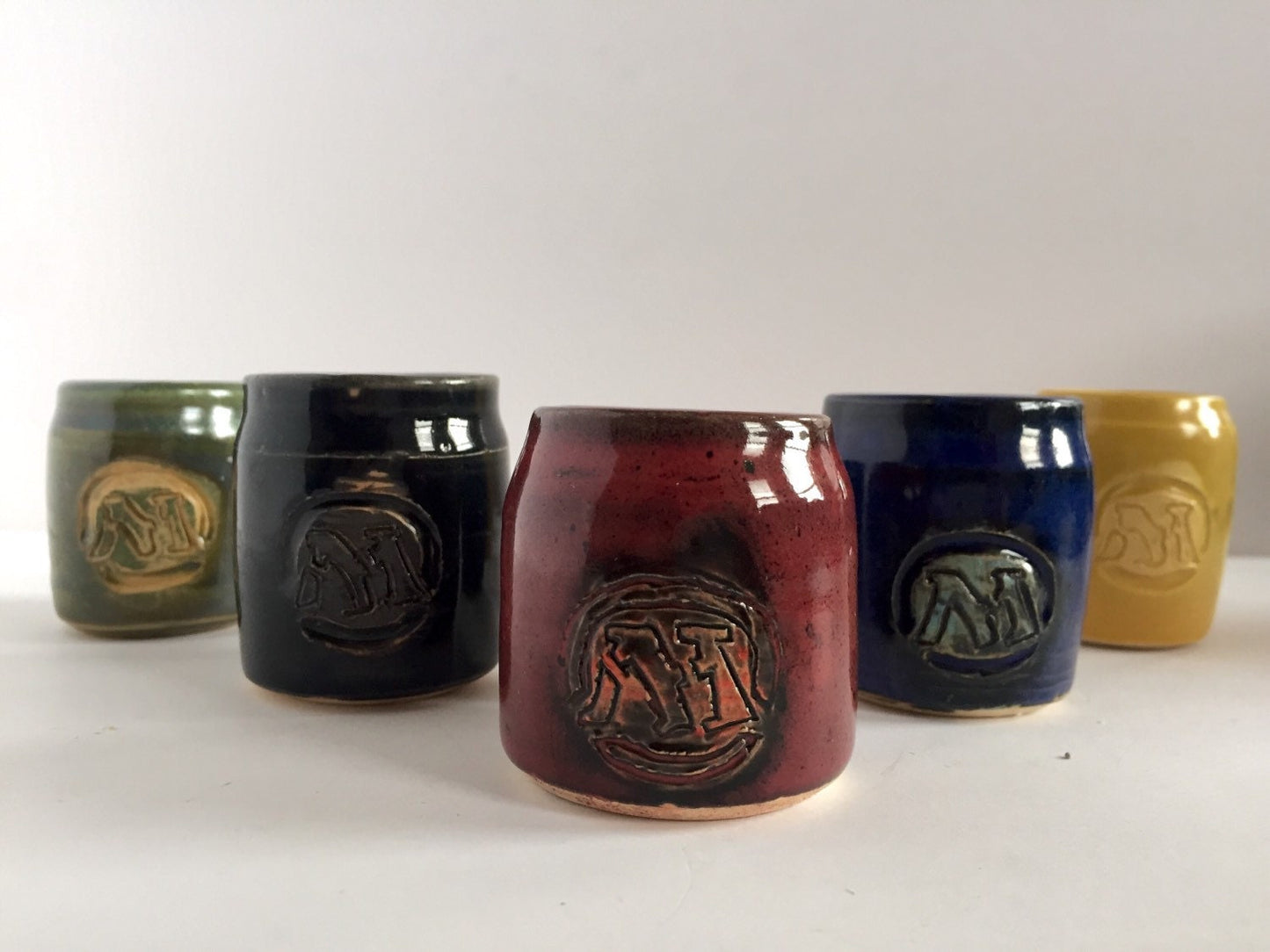 Handmade "magic the gathering" themed ceramic shot glasses with the five basic land