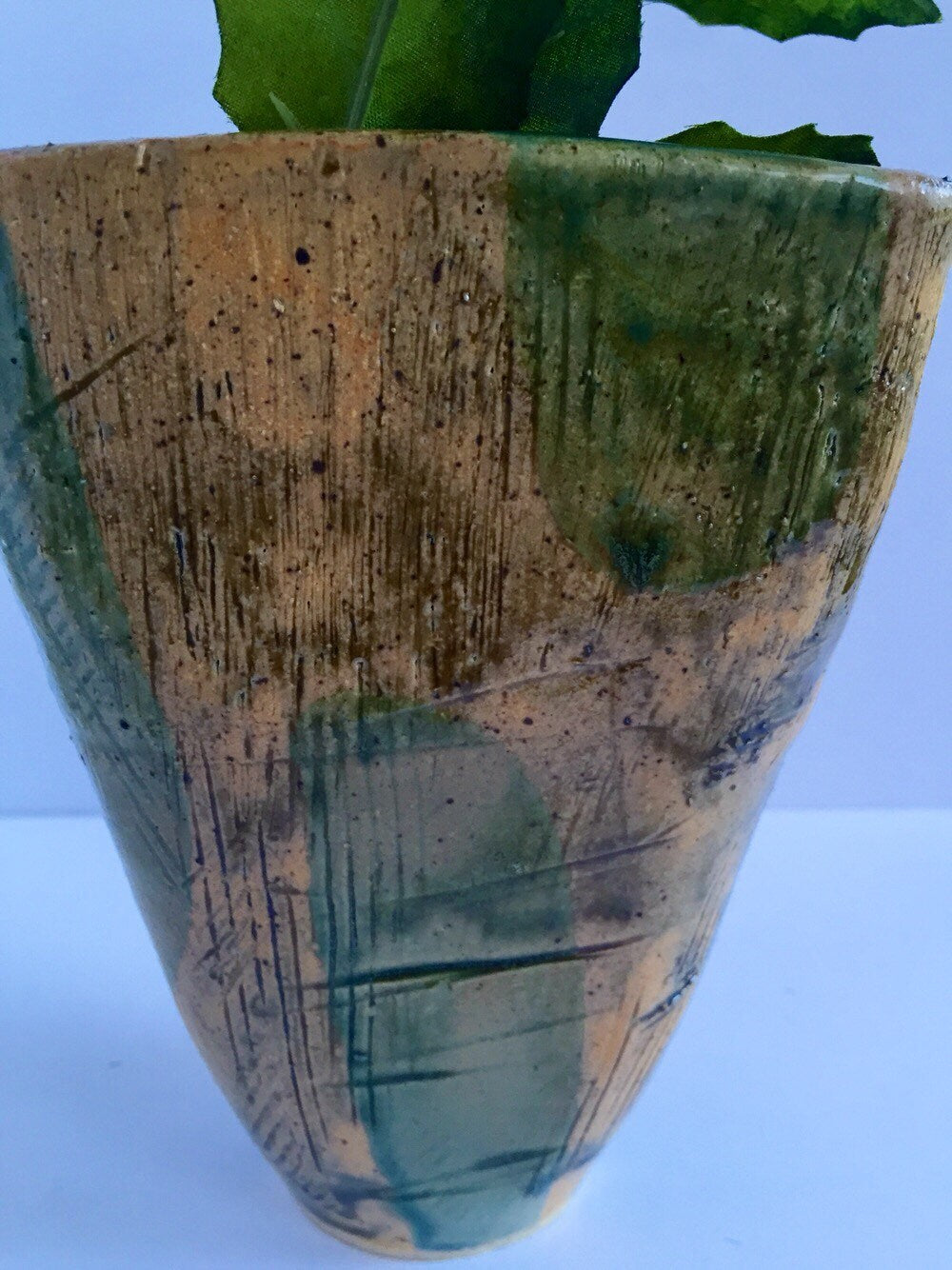 green vase ceramic with textured markings and square shape.
