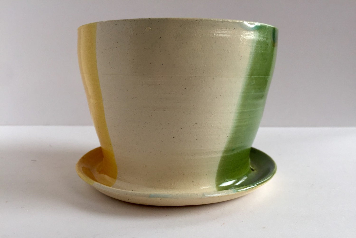 ceramic planter with attached base in green yellow and white