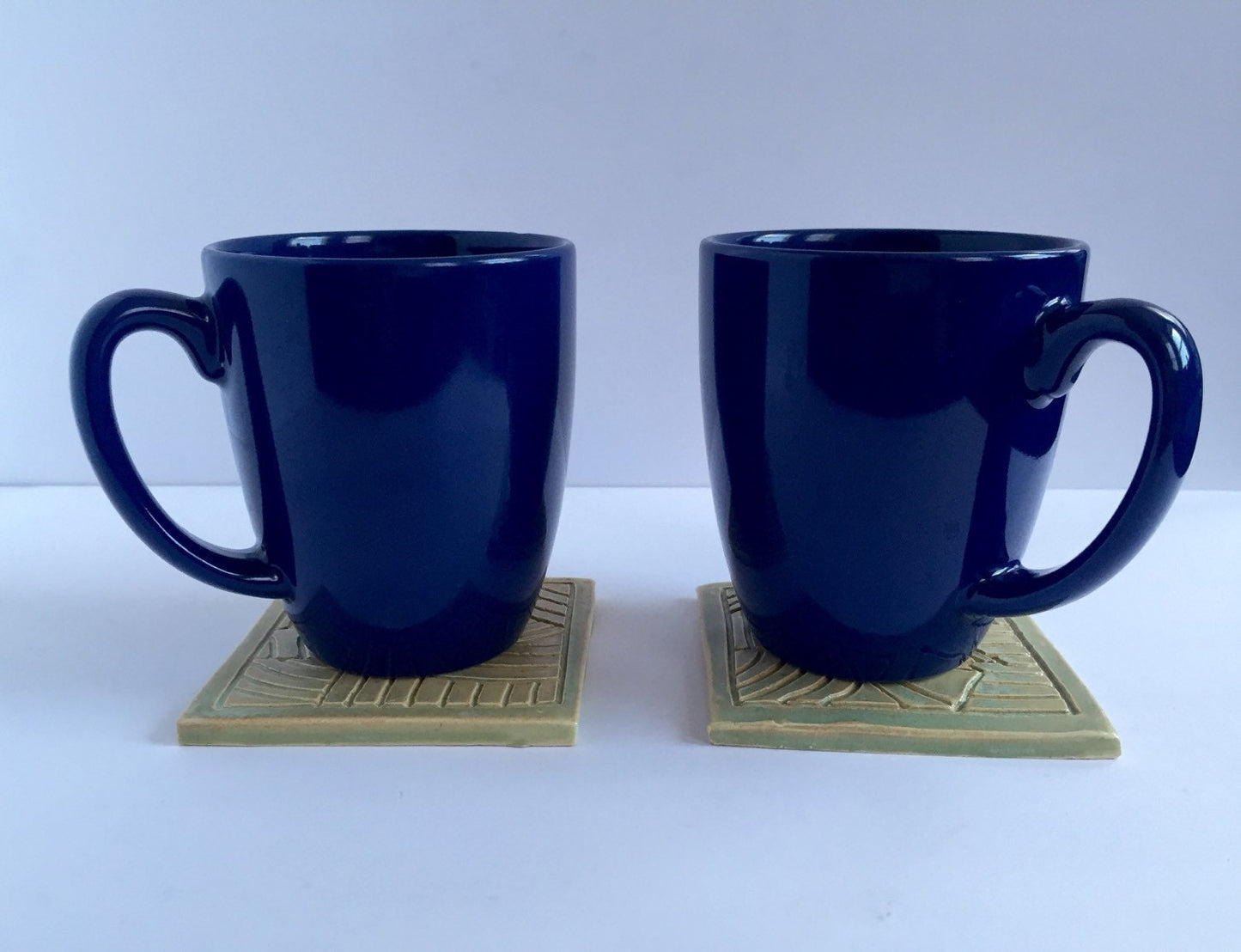 ceramic green coaster set of two with hand carved design