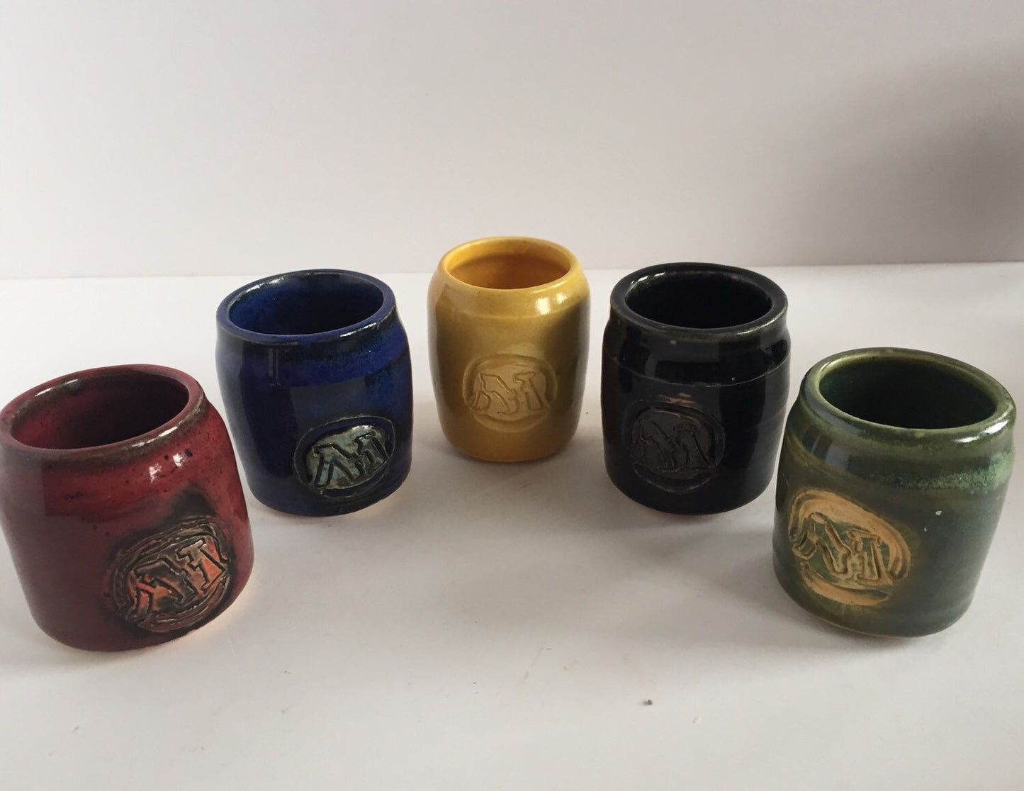 Handmade "magic the gathering" themed ceramic shot glasses with the five basic land