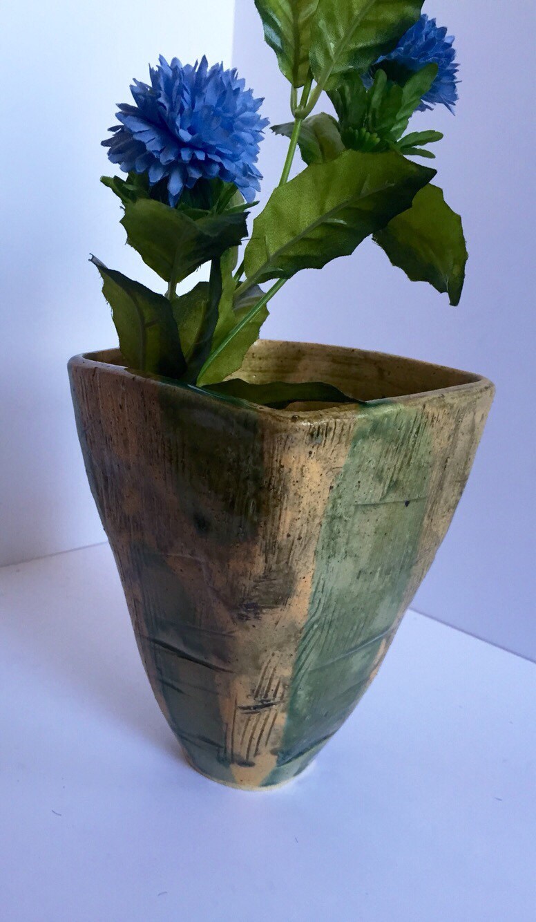 green vase ceramic with textured markings and square shape.