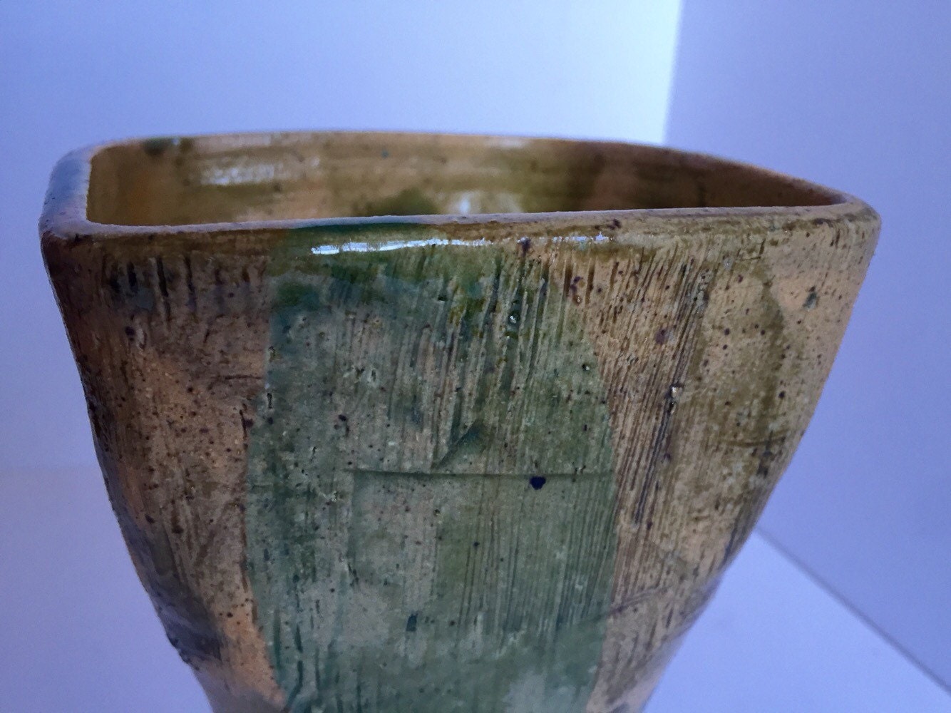 green vase ceramic with textured markings and square shape.