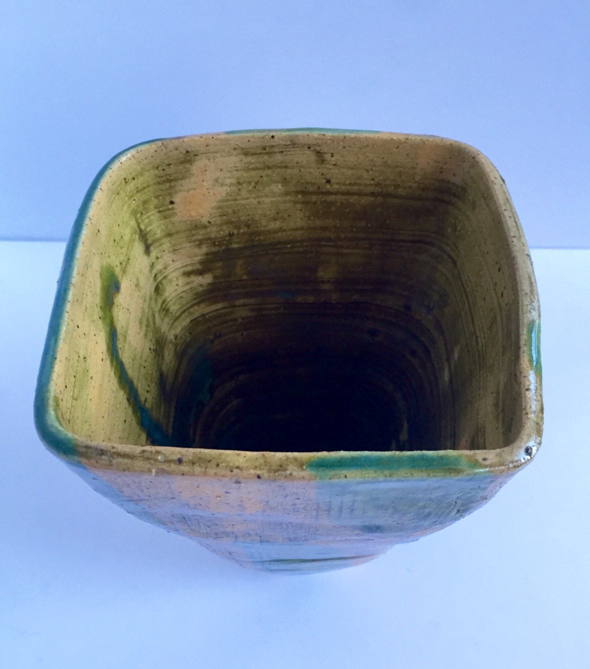 green vase ceramic with textured markings and square shape.