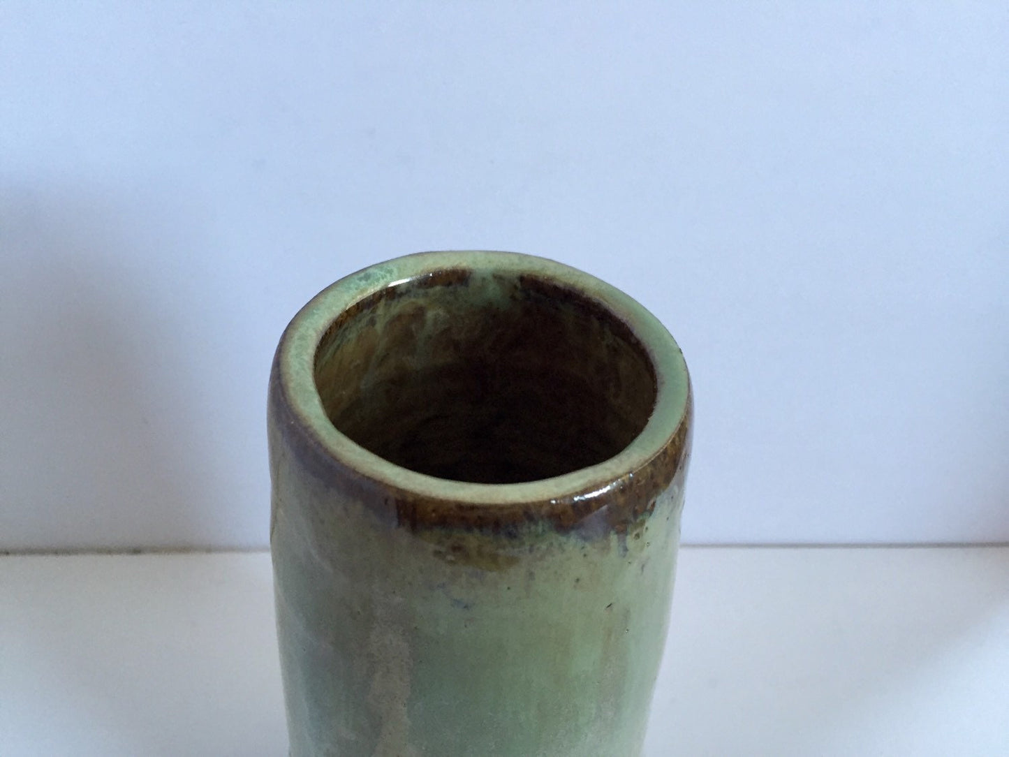 Tall Ceramic flower vase with blue/green glaze.