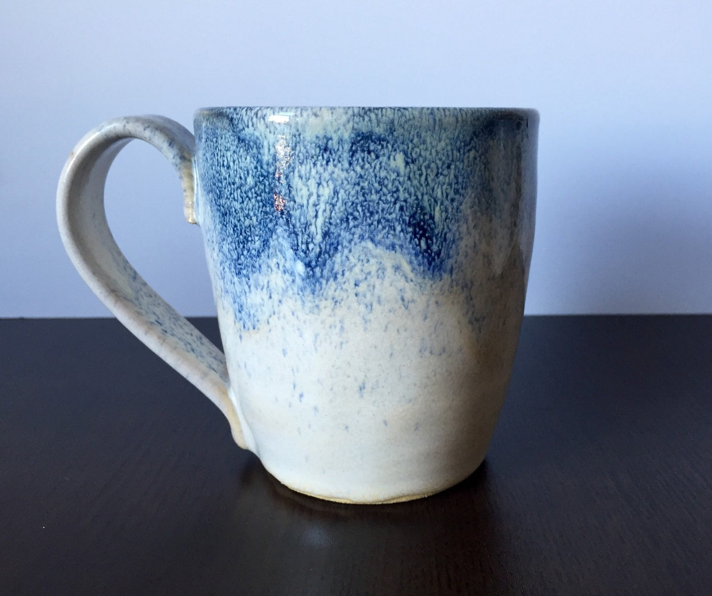 Ceramic coffee mug in white and blue snow fall.